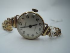 A lady's 9ct gold wrist watch by Ingersoll having Arabic numeral dial to white face in a gold case