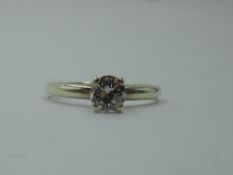 A diamond solitaire dress ring, approx 0.75ct, in a four claw raised mount on a 9ct white gold loop,