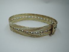 A 9ct three coloured gold plaited bracelet of chevron design having concealed clasp, approx 25.6g