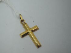A yellow metal cross pendant of plain form, bearing mark to loop, tests as 18ct gold, no chain,