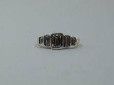 A five stone baguette cut diamond ring of graduated form, total approx 0.75ct, in a stepped collared