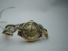 A lady's vintage 9ct gold Omega wrist watch having a baton numeral dial to champagne face in a 9ct