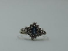 A powder blue sapphire and diamond lozenge shaped cluster in a claw set basket mount on a 9ct gold
