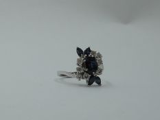 A lady's dress ring having a central sapphire, approx 0.75ct surrounded by four marquise cut