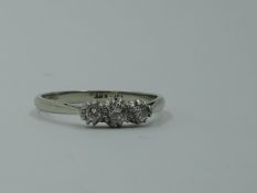 A diamond trilogy dress ring, total approx 0.20ct in a claw set mount on a white metal loop