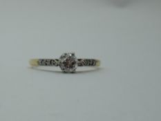 A diamond solitaire, approx 0.25ct dress ring in a raised claw set mount to diamond chip set