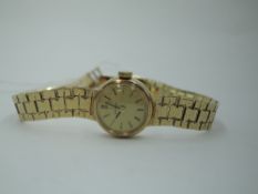 A lady's 9ct gold Omega wrist watch having a baton numeral dial to champagne face in a gold case