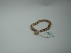 A rose metal curb chain bracelet stamped 9ct having engraved links and a padlock clasp, approx 11.