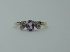 An amethyst dress ring having diamond chip decoartive panels to shoulders on a 9ct gold loop, size P