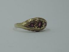 A 9ct gold band ring having a trio of inset graduated rubies in a shaped panel, size N & 1.6g