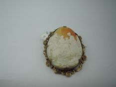 A large conch shell cameo brooch having a scenic panel depicting a women tending injured soldiers in