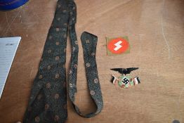 A German 1930's Tie decorated with swastika's, a SS Cloth Badge and a similar cloth badge with