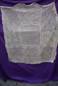 An antique cream christening shawl.