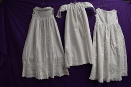 Three Victorian childrens gowns, lace and pin tuck details to hems of some.