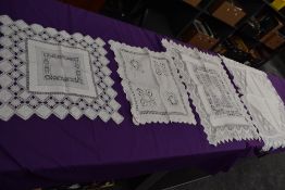 A collection of intricate antique table linen, various techniques used, tray cloths and similar
