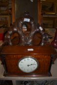 A late Victorian mantle clock having French movement with an oak cutlery carrier and carved photo