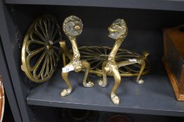 Two large brass fire trivets and a pair of lion head fire side dogs