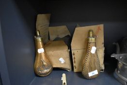 Two antique powder gun shot flasks one decorated with game bird and similar