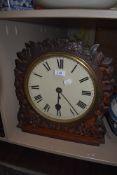 A wall mounted fusee clock having arts and crafts style carved frontage with vine and fruit leaves
