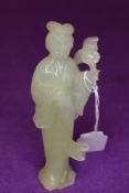 A hand carved pale jade figure of a oriental lady with flowers 12cm tall