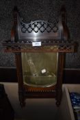 A Victorian gothic style wall mounted mirror having fretwork shelf