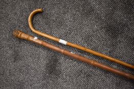 A bent wood walking stick and a similar bamboo cane