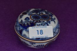 A small porcelain lidded pin dish bearing crossed Meissen swords decorated with bird and foliage
