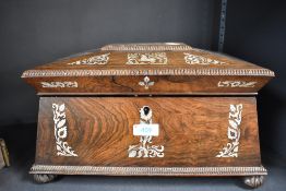 A 19th century rose wood tea caddy of sarcophagus form with mother of pearl inlay and fitted