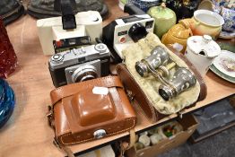 Two Polaroid cameras, a Dacora dignette and a pair of decorated opera glasses