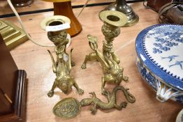 A pair of finely cast mythical dragon form chamber candle sticks and a similar spoon