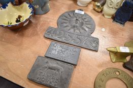 Three lead insurance style plaques including Tamar, Sun and O M E G