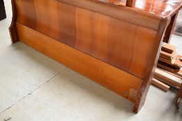 A modern hardwood bedstead, sleigh style, width approx. 6ft