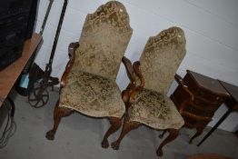A pair of traditional stained frame upholstered arm chairs having elaborate cabriole legs and paw