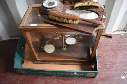A traditional glass cased lab scale and a wall mirror/barometer