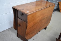 A mid 20th Cetury part walnut gateleg table with cupboard to end