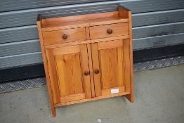 A stained pine bathroom cabinet