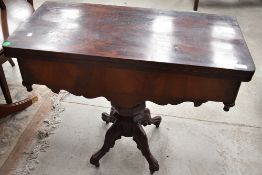 A 19th Century rosewood fold over tea table, having shaped apron and quadruple splay legs, width