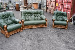 A modern wood frame and green leatherette three piece suite comprising two seater settee and two