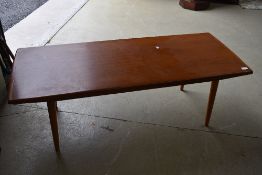 A 1970s teak coffee table on tapered legs, approx. 135 x 55cm