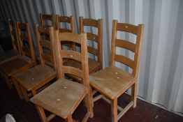 A set of eight traditional heavy wood frame ladder back kitchen dining chairs