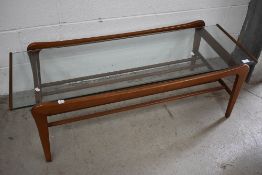 A 1970s glass top coffee table of stylised form, approx. 114 x 48cm