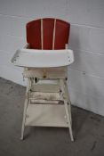 A vintage Childs folding high/low chair , wooden frame and vinyl seat