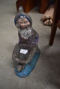 A concrete garden ornament, modelled as a garden gnome with barrow