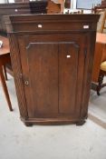 A 19th Century oak corner cupboard having shaped shelf interior