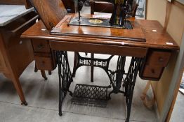 A late 19th or early 20th Century oak case treadle sewing machine, Singer