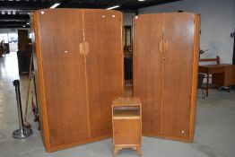 A vintage Austinsuite bedroom suite comprising two graduated wardrobes and a bedside cabinet , in