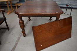 A 19th Century oak windout dining table, having canted top on turned legs, width approx 105cm,