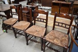 A set of four 19th Century spindle back kitchen chairs having rush seats