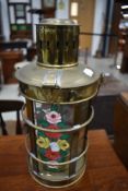 A traditional brass storm or barge lantern having romany style painted decoration to glass