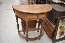 A traditional oak demi lune hall table, having twist gate leg and back flap, width approx. 77cm